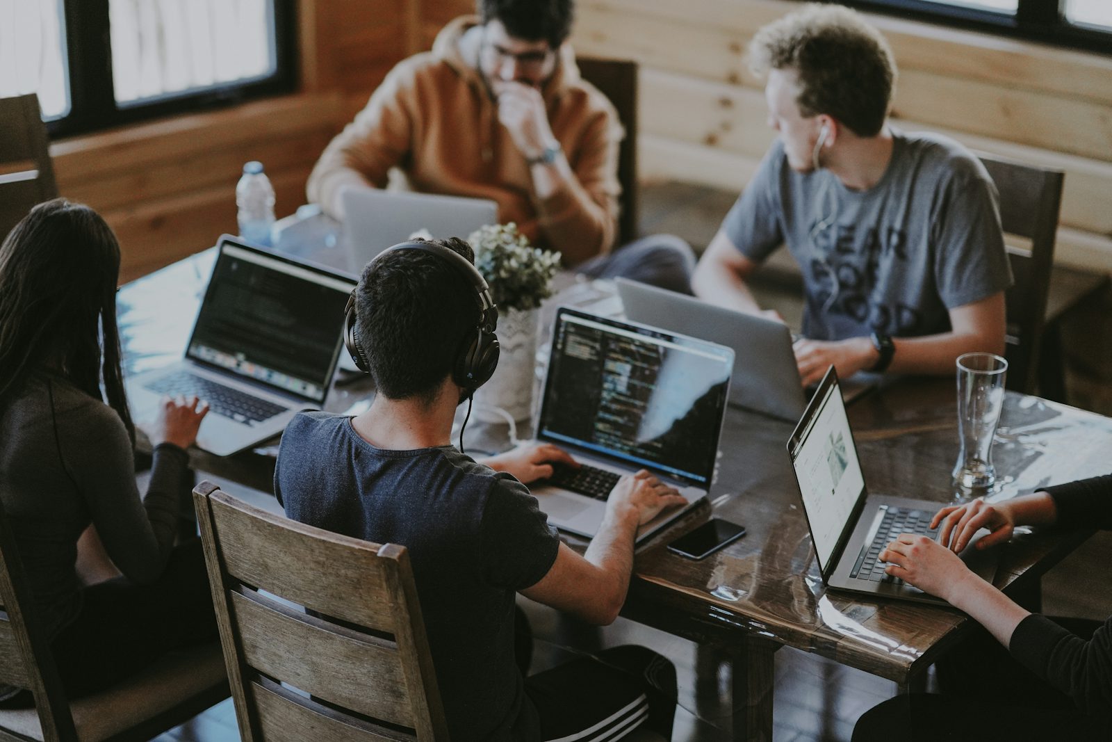 A team of coworkers collaborating around a laptop in a modern office